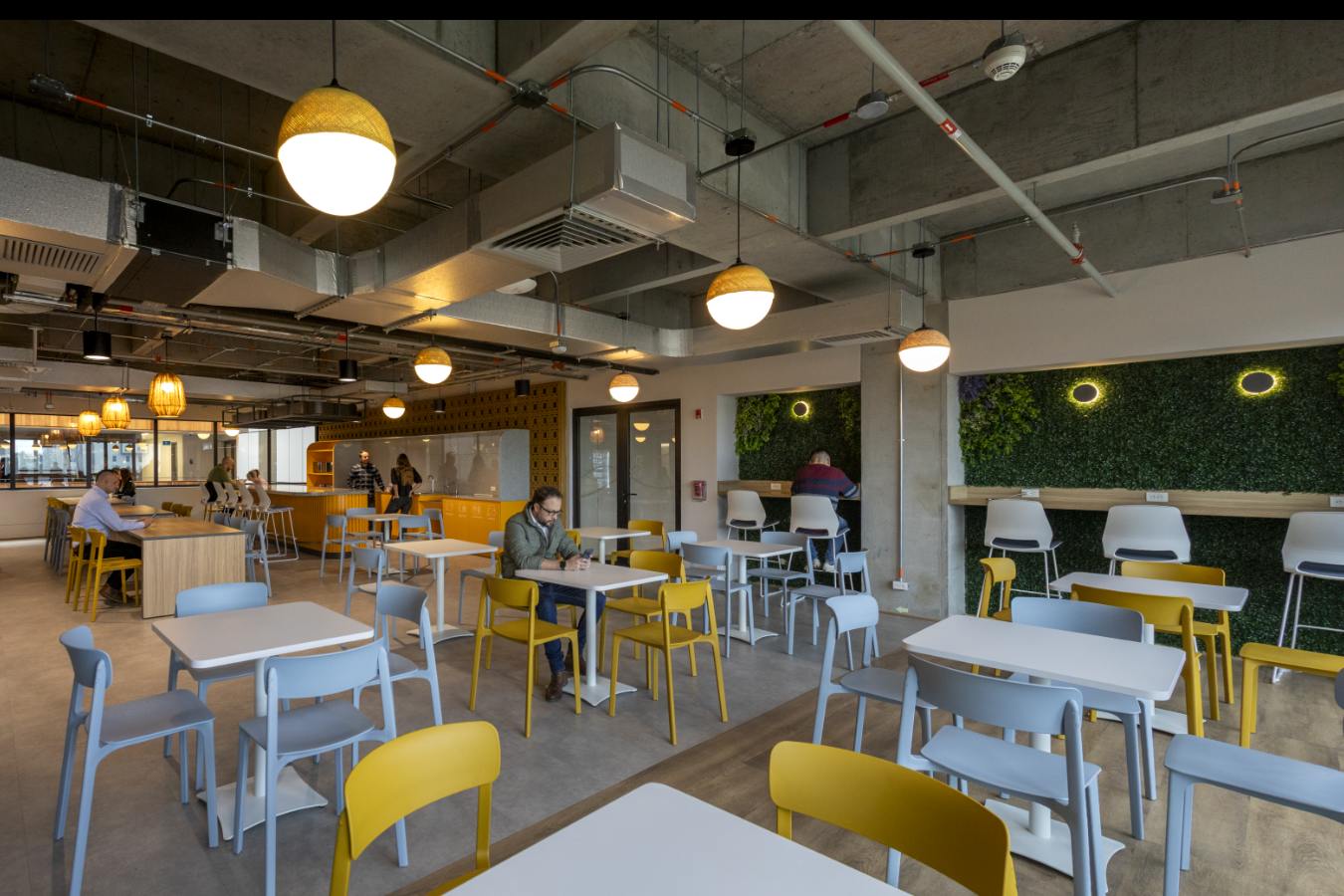 Emapta Offices - Spacious corporate town hall and dining area with yellow accent furniture - Contract Workplaces.jpg